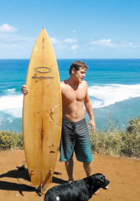 Jeff Horton shows the shark bite mark on his board after the attack at Pila'a, Kauai.